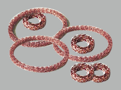 Several tinned copper steel compressed knitted mesh gaskets on the gray background.