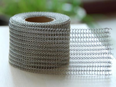 A roll of stainless steel knitted mesh fabric on the table.