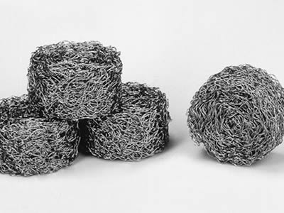 Four round compressed knitted wire meshes on the white background.