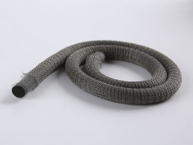 A roll of knitted mesh gasket with round foam on the gray background.
