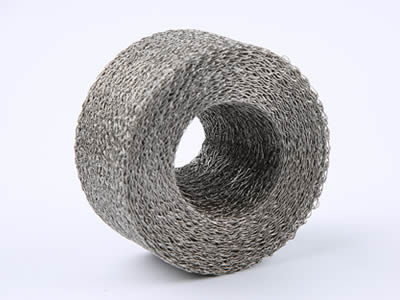 A compressed knitted mesh cylinder is standing on the gray background.