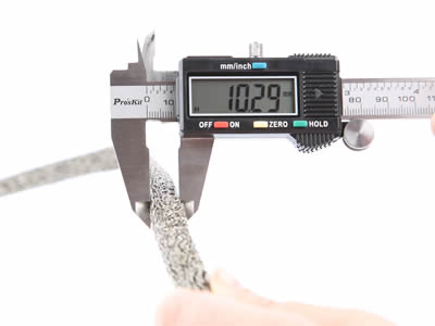 Un calibrador vernier mide la altura de la junta de malla de punto comprimida. 