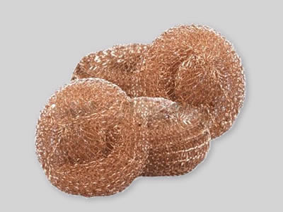 Four copper knitted cleaning balls on the white background.