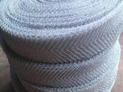 Trois rouleaux de mailles tricotées en acier inoxydable sur fond blanc.