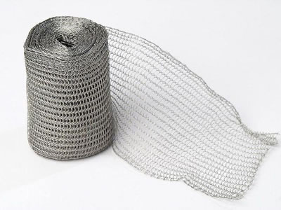 A roll of flattened stainless steel knitted mesh on the white background.