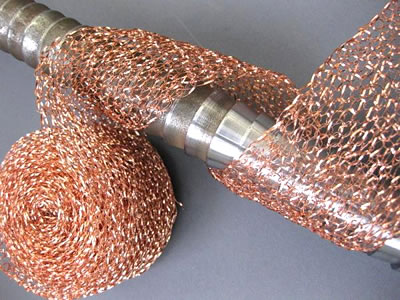 A roll of knitted wire cleaning mesh is cleaning a mechanical parts.