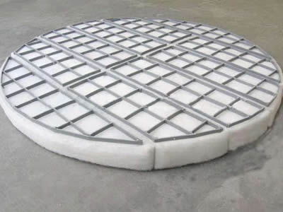 A knitted wire demister pad with metal frame.