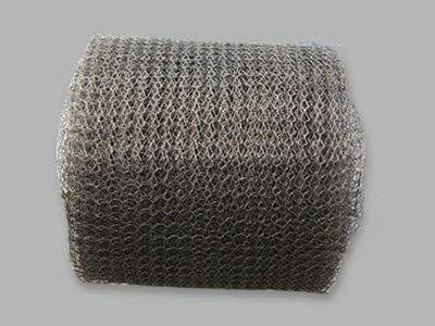 Un rouleau de treillis métallique tricoté en acier inoxydable sur fond blanc.