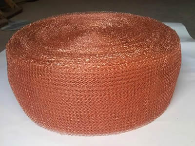 A roll of copper knitted wire mesh tape on the white background.