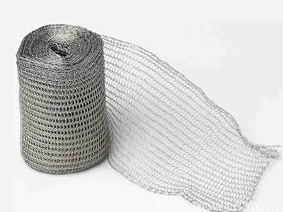 A roll of stainless steel knitted wire mesh on the white background.